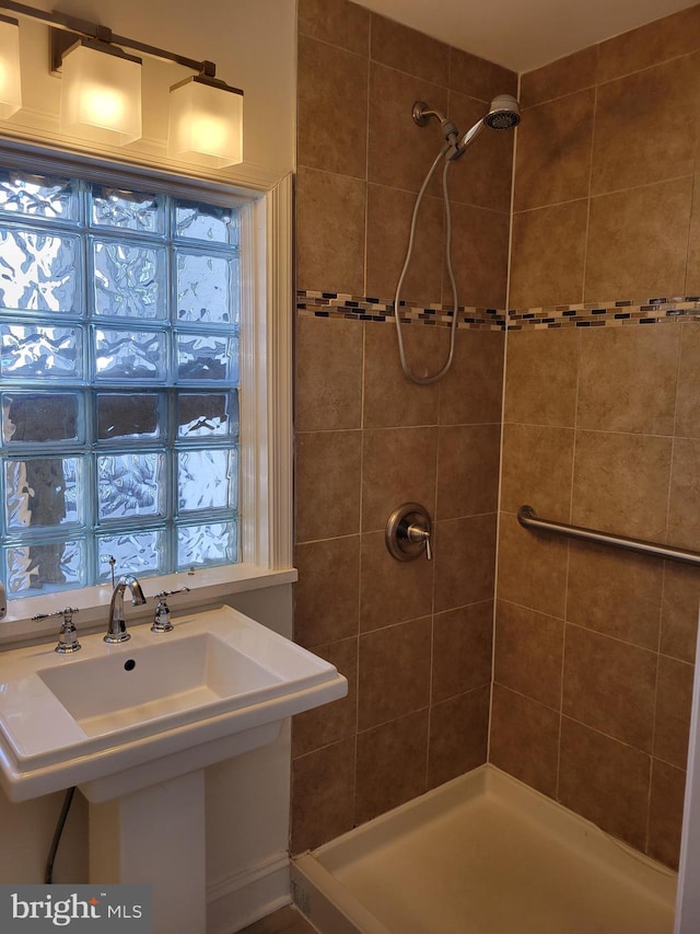 full bathroom with a sink and tiled shower