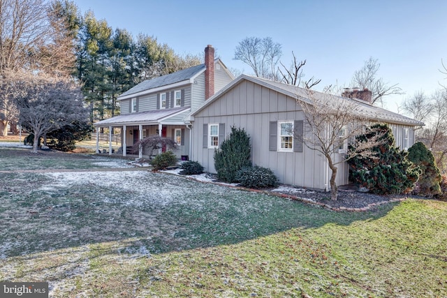 view of side of property with a porch and a yard