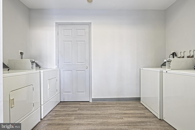 laundry area with washing machine and dryer and light wood-type flooring