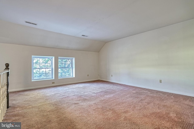 carpeted empty room featuring lofted ceiling