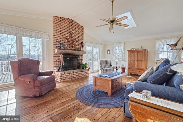 living room with a wealth of natural light, ceiling fan, wood-type flooring, and lofted ceiling