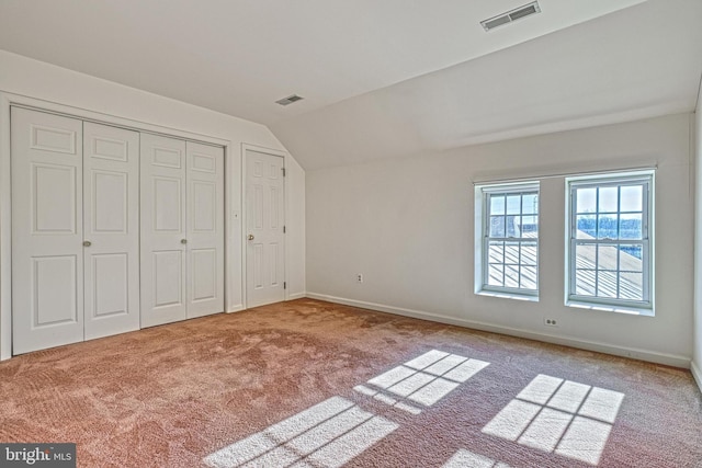 unfurnished bedroom with carpet and vaulted ceiling