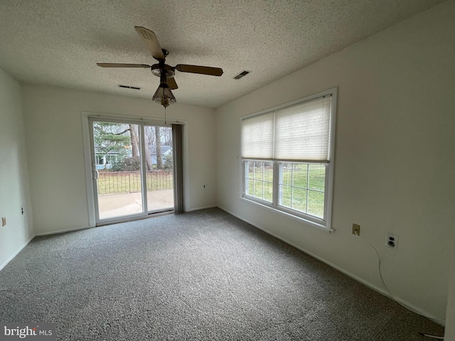 carpeted spare room featuring a textured ceiling and ceiling fan