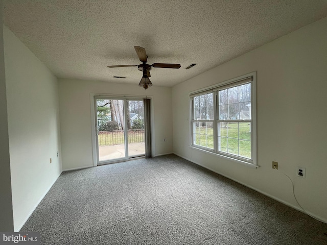 carpeted empty room featuring ceiling fan and a textured ceiling