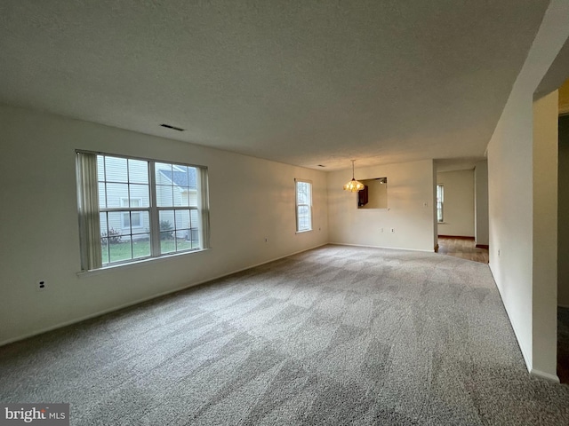 carpeted spare room with a textured ceiling