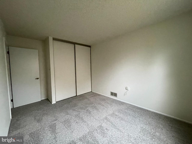 unfurnished bedroom with carpet flooring, a closet, and a textured ceiling