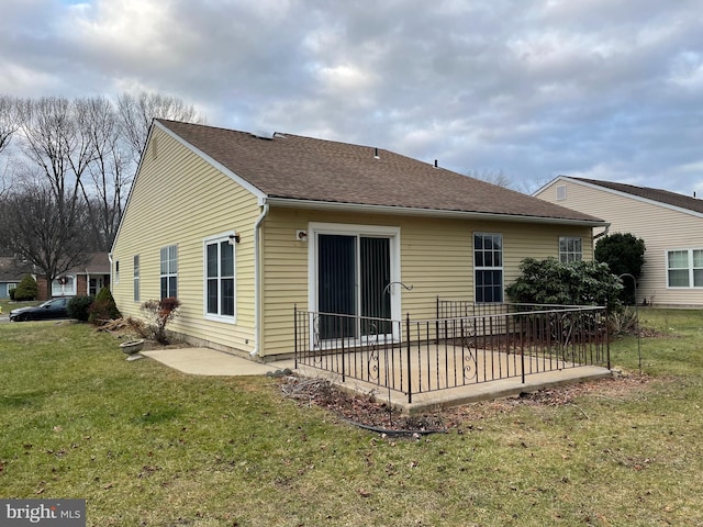 back of house with a yard and a patio