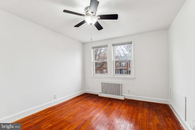 spare room with ceiling fan, radiator heating unit, and dark hardwood / wood-style floors