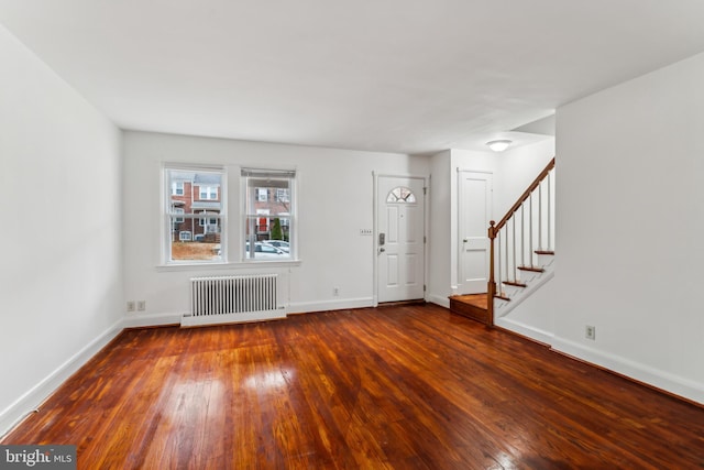 foyer entrance with hardwood / wood-style flooring and radiator