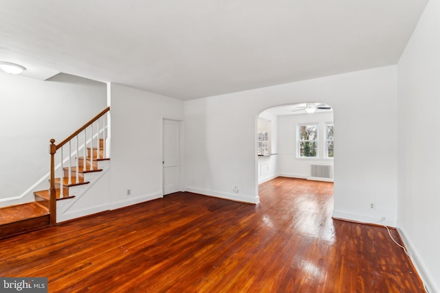 unfurnished living room featuring hardwood / wood-style floors, ceiling fan, and radiator