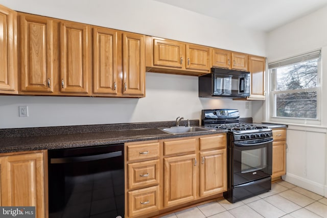 kitchen featuring light tile patterned floors, sink, and black appliances