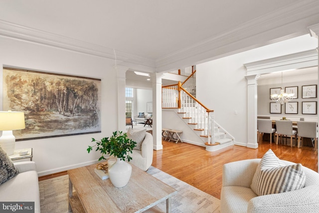 living room with ornamental molding, decorative columns, and hardwood / wood-style floors