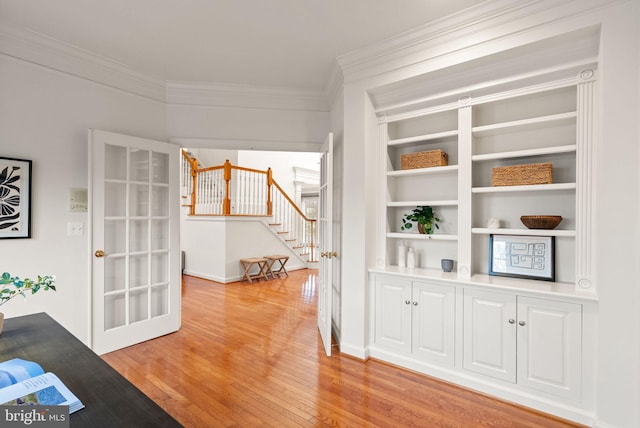 interior space with crown molding, french doors, and light wood-type flooring