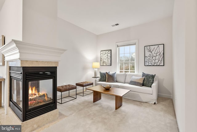 carpeted living room with a multi sided fireplace