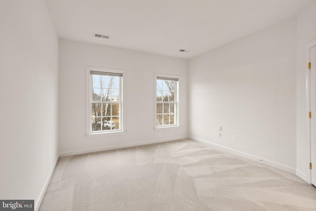 unfurnished room featuring light carpet