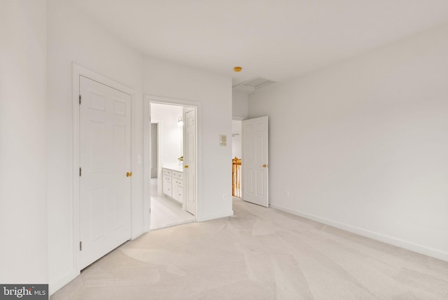 unfurnished bedroom featuring ensuite bathroom and light carpet