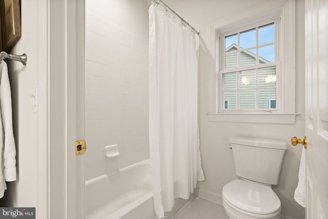 bathroom with shower / bath combination with curtain, tile patterned floors, and toilet