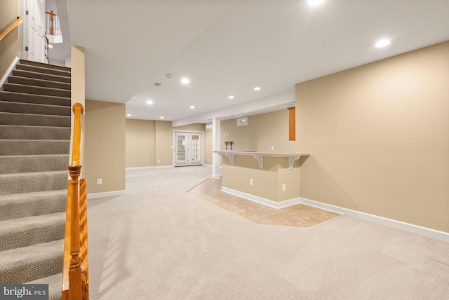 basement with light carpet and indoor bar