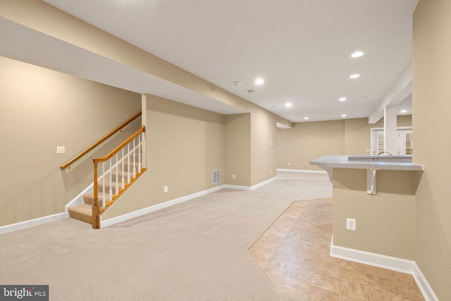 basement featuring sink and light carpet