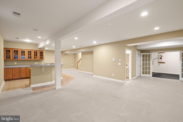 interior space with a breakfast bar area and light colored carpet