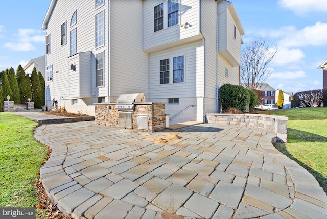 exterior space featuring a patio area, a lawn, and an outdoor kitchen