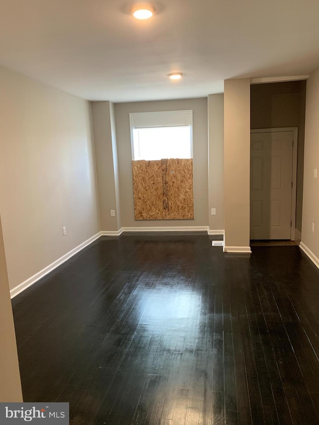 spare room featuring dark wood-type flooring