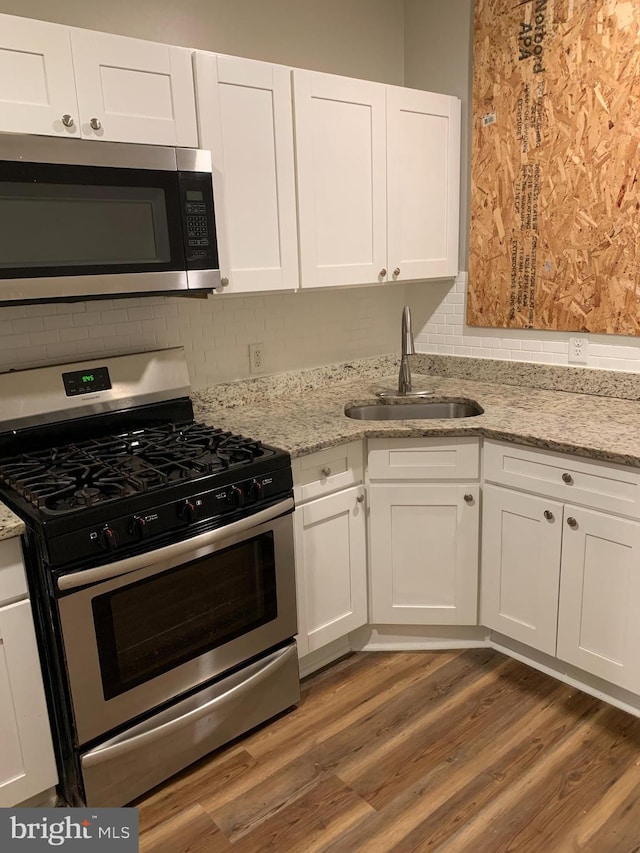 kitchen featuring white cabinets, dark hardwood / wood-style flooring, sink, and appliances with stainless steel finishes