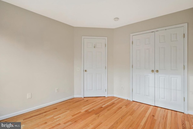 unfurnished bedroom with hardwood / wood-style flooring and a closet