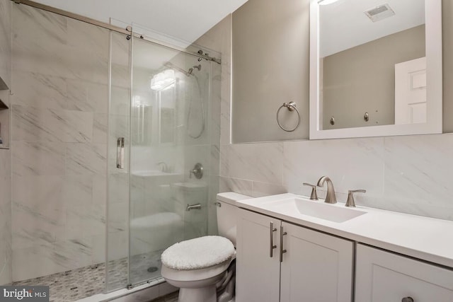 bathroom featuring vanity, backsplash, toilet, tile walls, and an enclosed shower