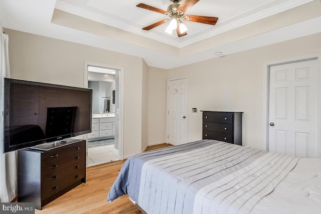 bedroom featuring ensuite bathroom, a raised ceiling, ceiling fan, and crown molding