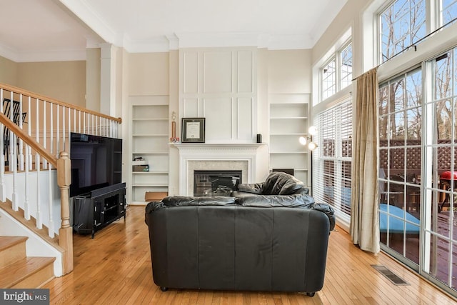 living room featuring light wood-type flooring and crown molding