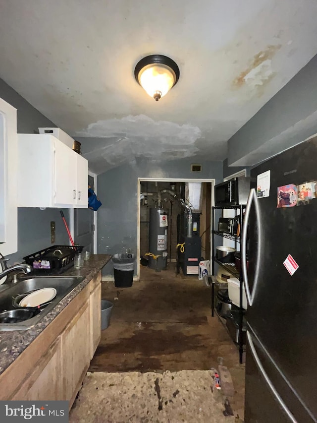 kitchen featuring stainless steel refrigerator, sink, water heater, heating unit, and light brown cabinetry