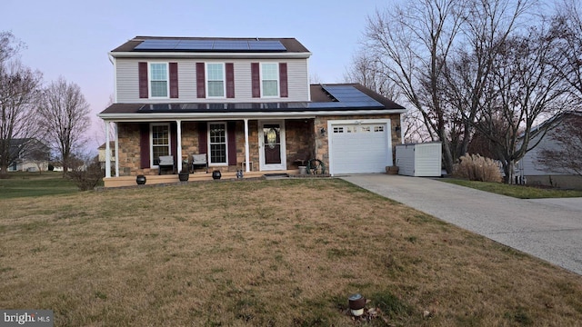 view of property with covered porch, a garage, solar panels, and a front lawn