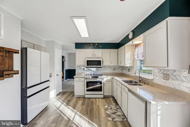 kitchen with light hardwood / wood-style floors, tasteful backsplash, white appliances, white cabinets, and sink