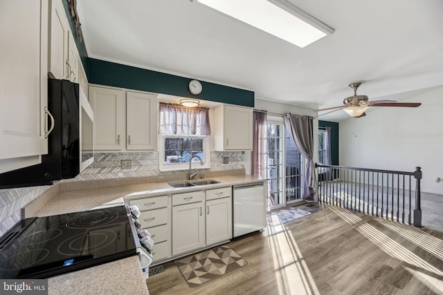 kitchen with white cabinetry, dishwashing machine, stainless steel electric range, light hardwood / wood-style flooring, and sink