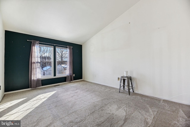 carpeted empty room with lofted ceiling