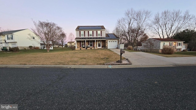 view of front of house with a lawn, solar panels, a porch, and a garage