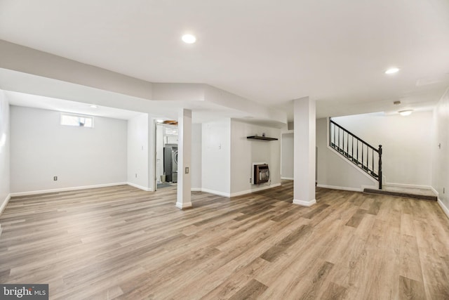 unfurnished living room featuring heating unit and light hardwood / wood-style floors