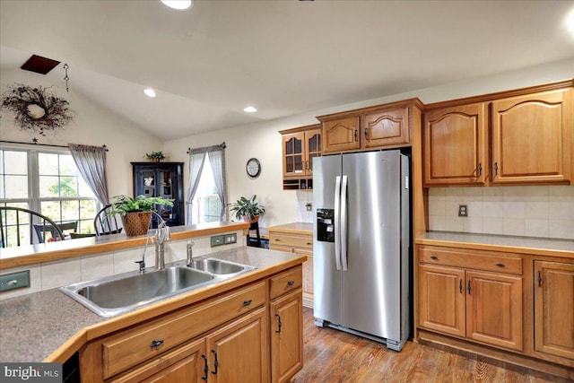 kitchen with decorative backsplash, sink, hardwood / wood-style flooring, stainless steel fridge with ice dispenser, and lofted ceiling