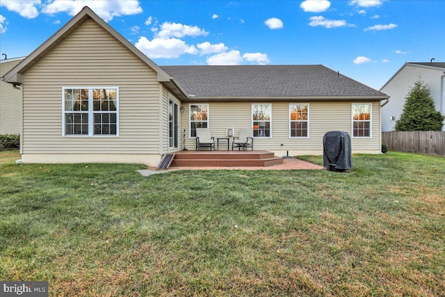 rear view of house featuring a lawn and a deck