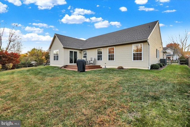 rear view of house with cooling unit, a deck, and a yard