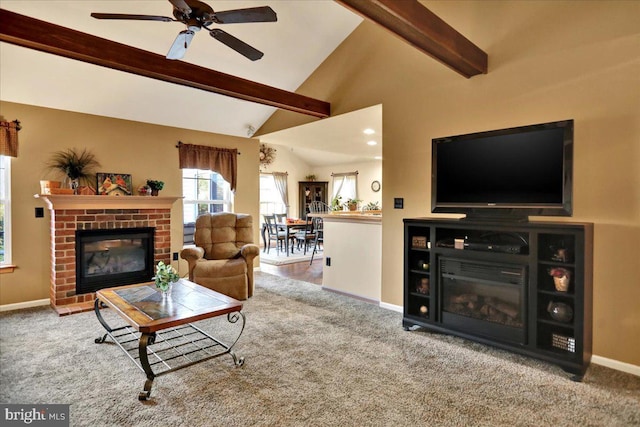 living room with carpet, vaulted ceiling with beams, ceiling fan, and a brick fireplace