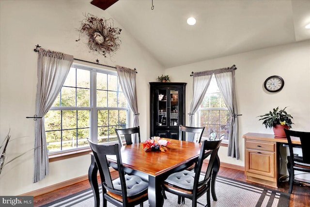 dining space with dark hardwood / wood-style floors and vaulted ceiling