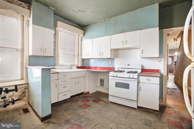 kitchen featuring white cabinets, sink, and white gas range oven