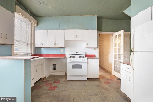 kitchen featuring white appliances, white cabinetry, and sink