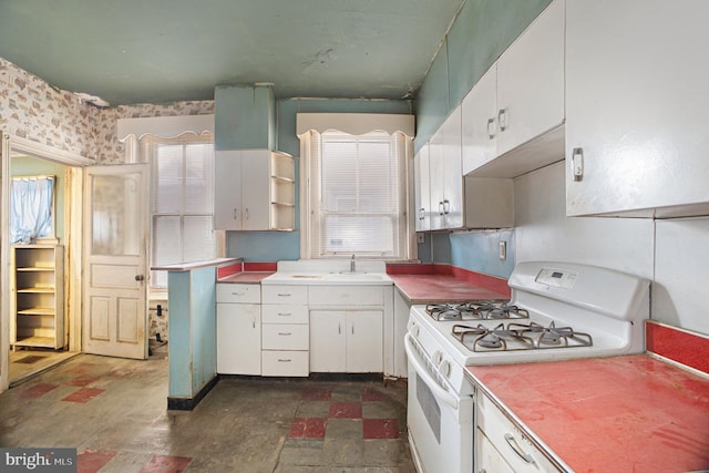 kitchen with sink, white cabinetry, and gas range gas stove