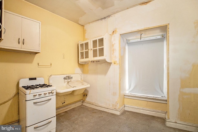 kitchen featuring sink, white cabinetry, and white range with gas cooktop