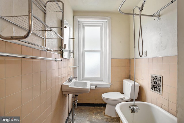 bathroom featuring toilet, concrete flooring, and tile walls