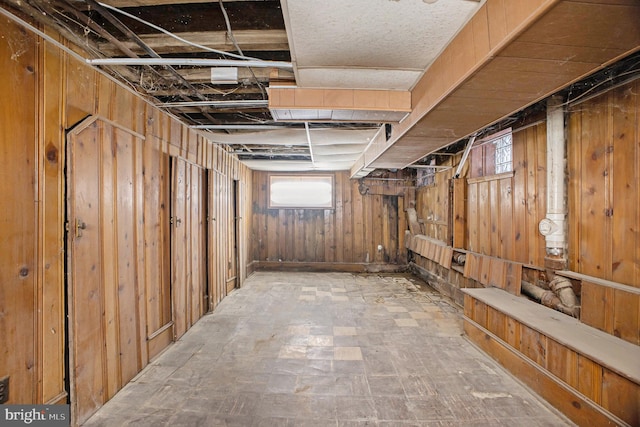 basement featuring wooden walls