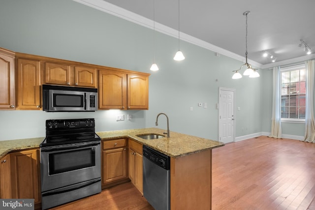 kitchen with crown molding, sink, decorative light fixtures, kitchen peninsula, and stainless steel appliances